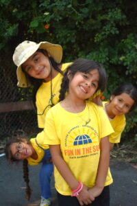 4 smiling girls in yellow shirts